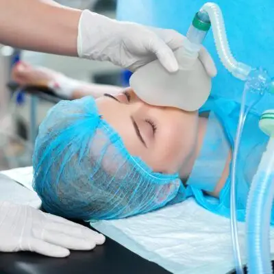 Anestesiologia Close up shot of a nurse holding oxygen mask on a young woman during surgical treatment at the hospital health vitality emergency reanimation concept.
