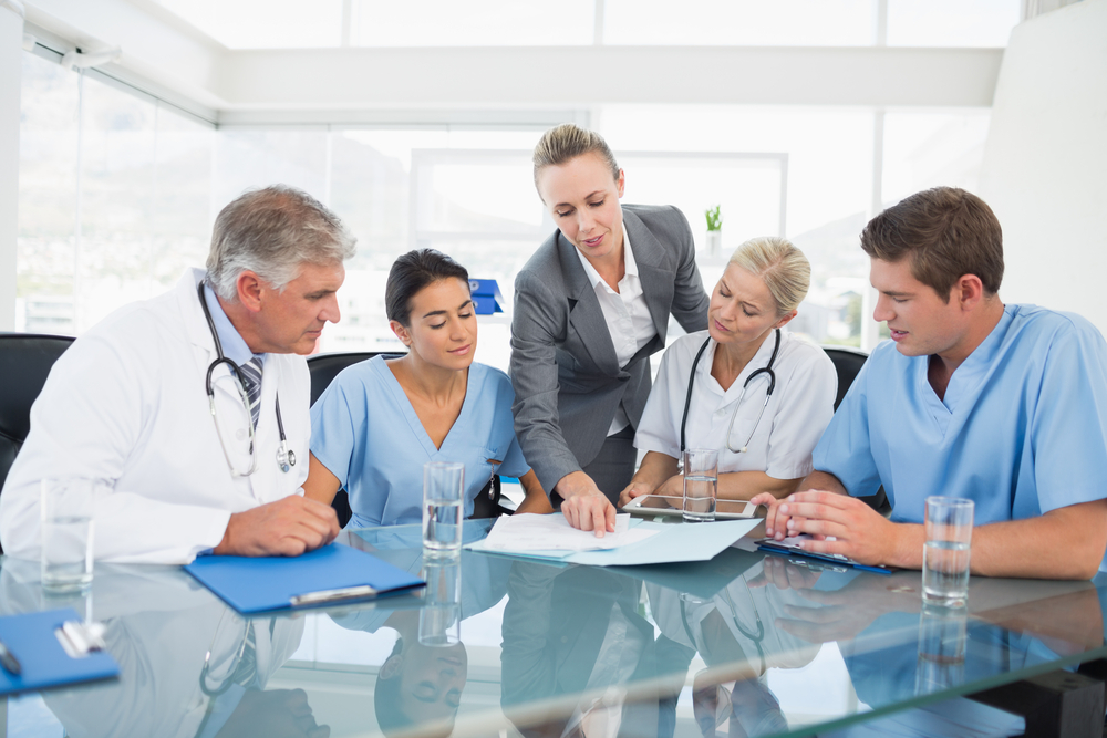 Team,Of,Doctors,And,Businesswoman,Having,A,Meeting,In,Medical