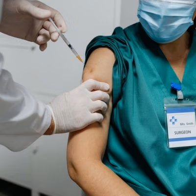 Unrecognizable,Female,Surgeon,Receiving,Coronavirus,Vaccine,At,Doctor's,Office