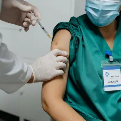 Unrecognizable,Female,Surgeon,Receiving,Coronavirus,Vaccine,At,Doctor’s,Office Unrecognizable,Female,Surgeon,Receiving,Coronavirus,Vaccine,At,Doctor's,Office