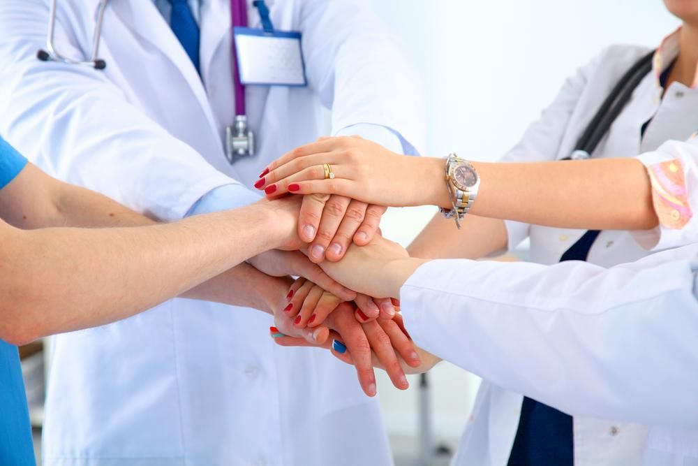 Doctors,And,Nurses,In,A,Medical,Team,Stacking,Hands