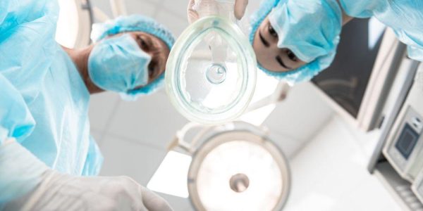Two,Serious,Doctors,Wearing,Blue,Masks,And,Looking,At,You