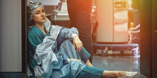 Tired,Doctor,Sitting,After,Surgery,In,The,Hospital,Corridor.,Great