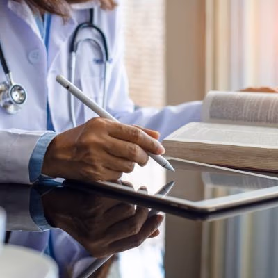Female,Doctor,In,White,Lab,Coat,Reading,Book,And,Work