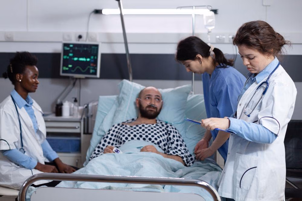 Doctor,With,Stethoscope,Reading,Lab,Results,While,Nurse,Is,Adjusting