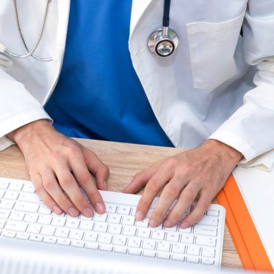 Doctor's,Hands,Typing,In,The,Computer