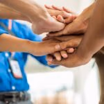 Large,Group,Of,Businessmen,Join,Hands,For,Business,Cooperation