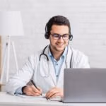 Smiling,Doctor,In,White,Coat,With,Stethoscope,And,Headphones,,Takes