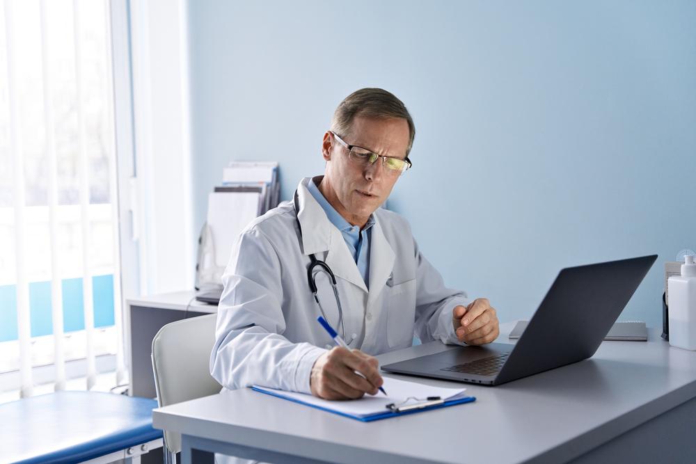 Serious,Old,Mature,Professional,Male,Doctor,Using,Laptop,Computer,In