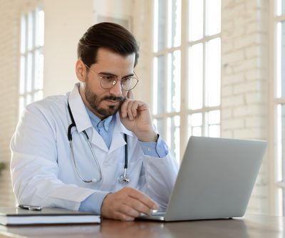 Focused,Serious,Young,Male,Doctor,In,Eyeglasses,And,White,Uniform