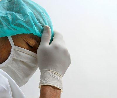 Doctor,Under,Pressure,With,Face,Mask,And,Gloves,In,Hospital