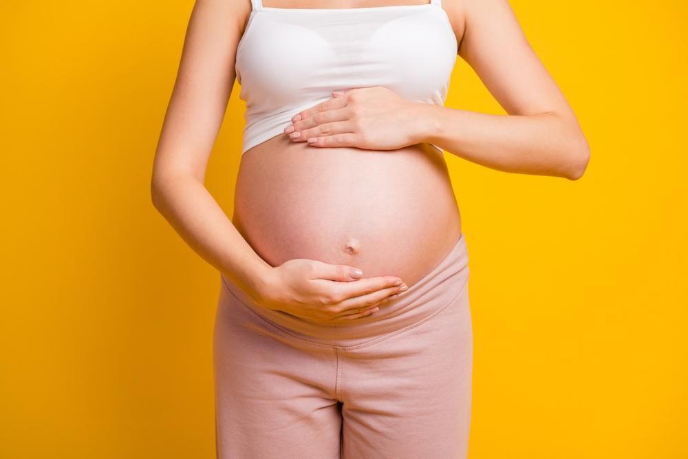 Cropped,View,Of,Attractive,Pregnant,Girl,Touching,Large,Stomach,Parenthood