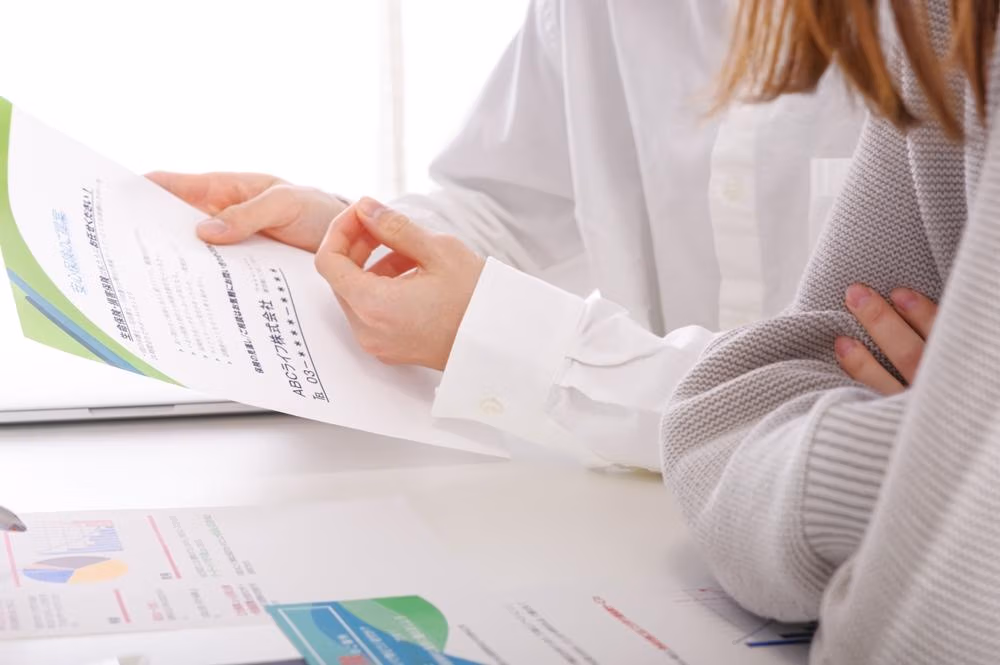 A,Couple,Considering,Insurance.,The,Flyer,Says,"insurance,Information",In
