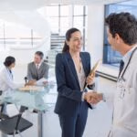 Doctor,And,Businesswoman,Handshaking,In,Meeting