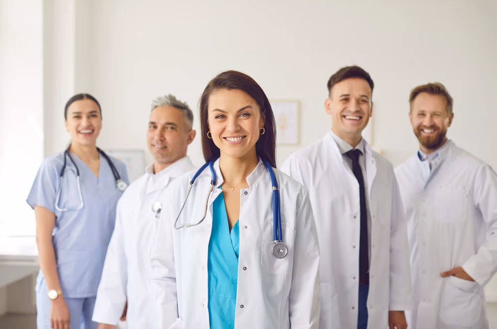 Portrait,Of,A,Happy,Woman,Doctor,Standing,With,A,Team Portrait,Of,A,Happy,Woman,Doctor,Standing,With,A,Team