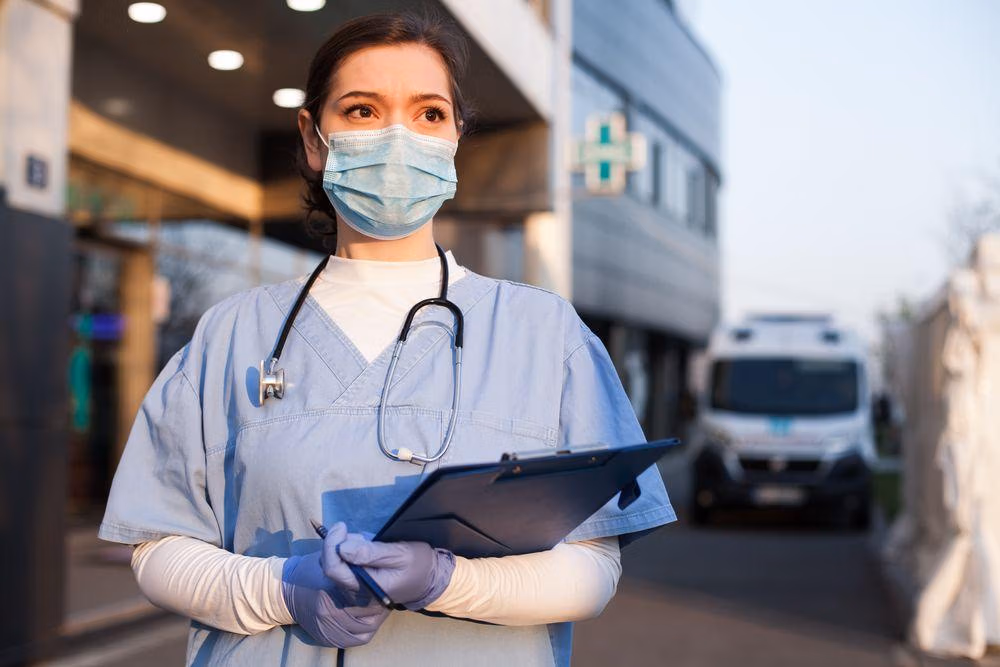 Young,Female,Ems,Key,Worker,Doctor,In,Front,Of,Healthcare Young,Female,Ems,Key,Worker,Doctor,In,Front,Of,Healthcare